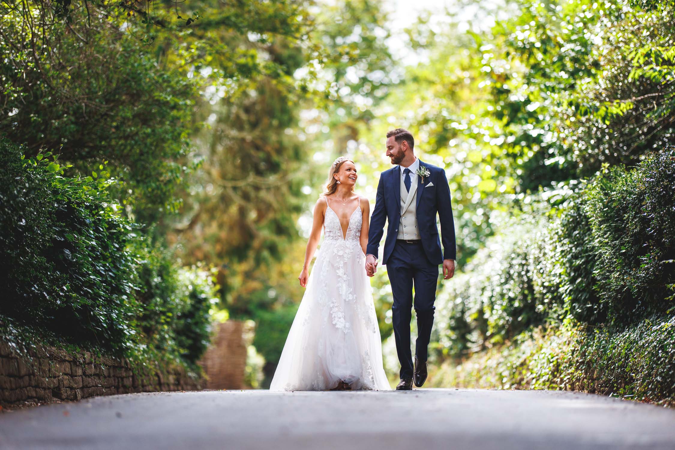 The bride and groom laughing while walking and looking at each other at Bredenbury Court Barns in Herefordshire.
