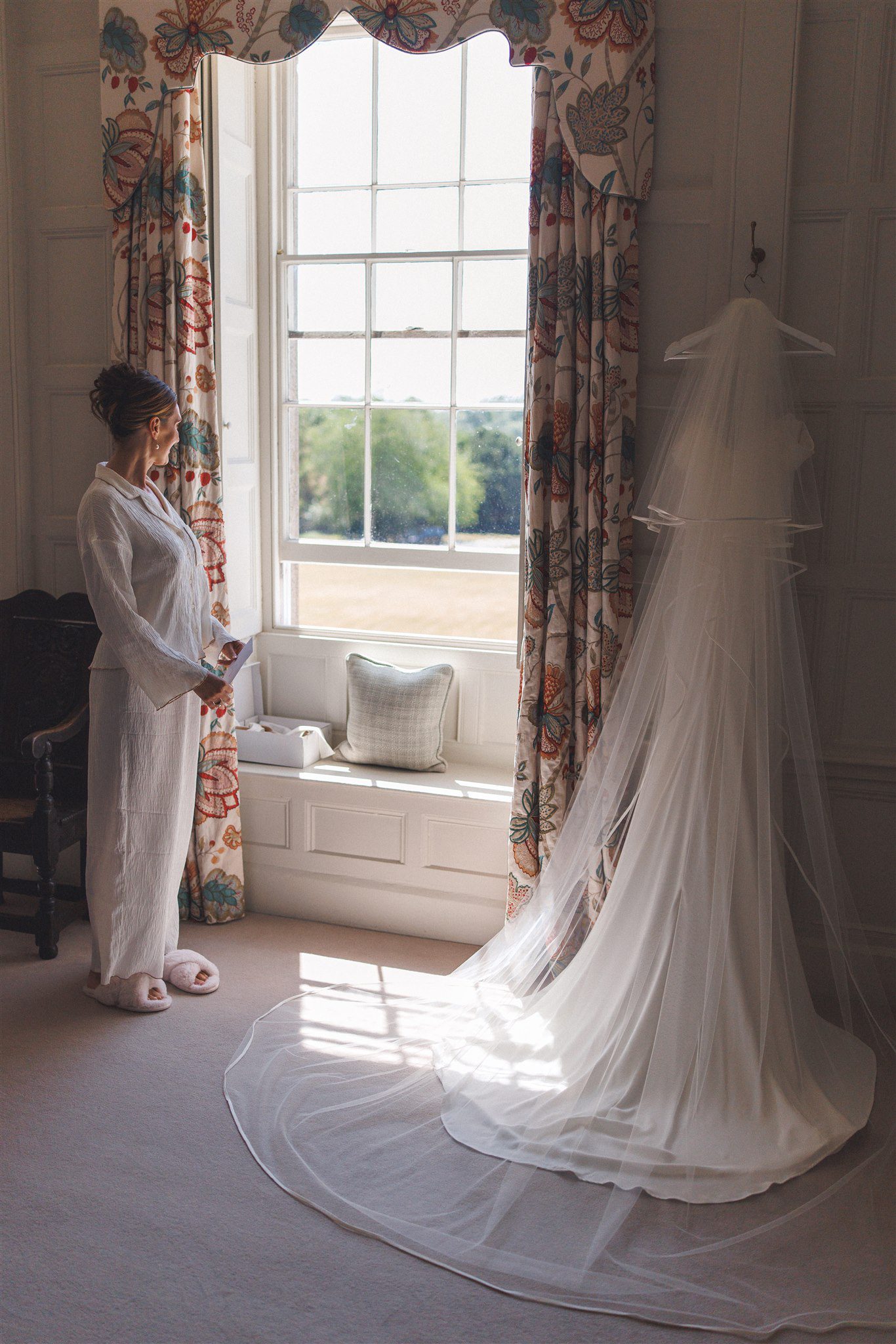 Zofia by the window at Elmore Court before the ceremony, her veil across the floor