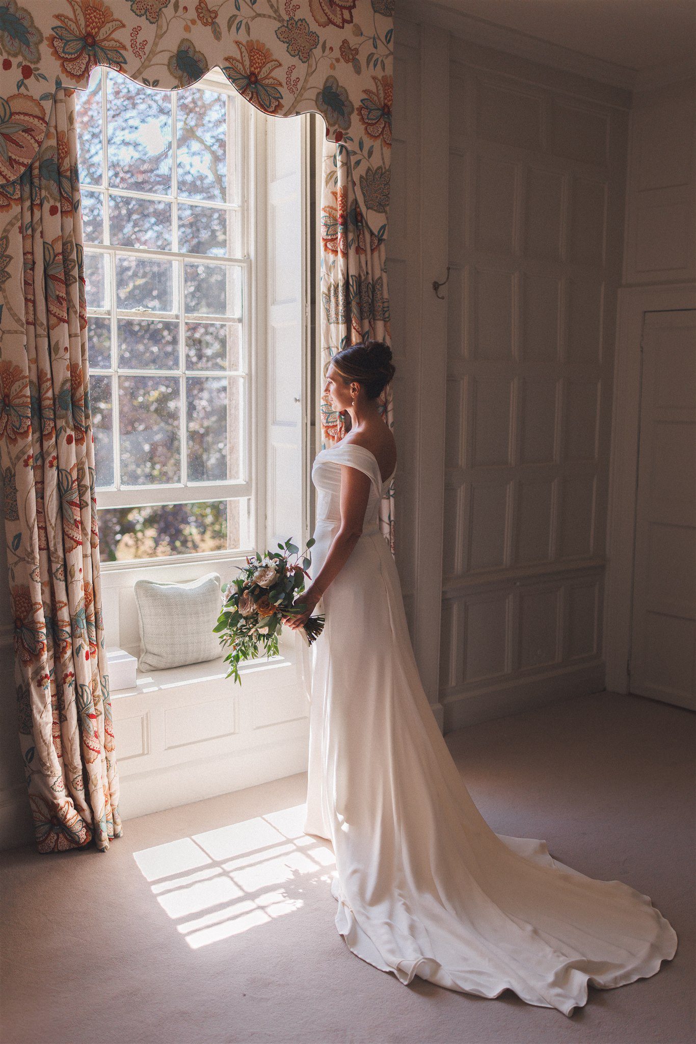 Zofia in the window light at Elmore Court, holding her bouquet