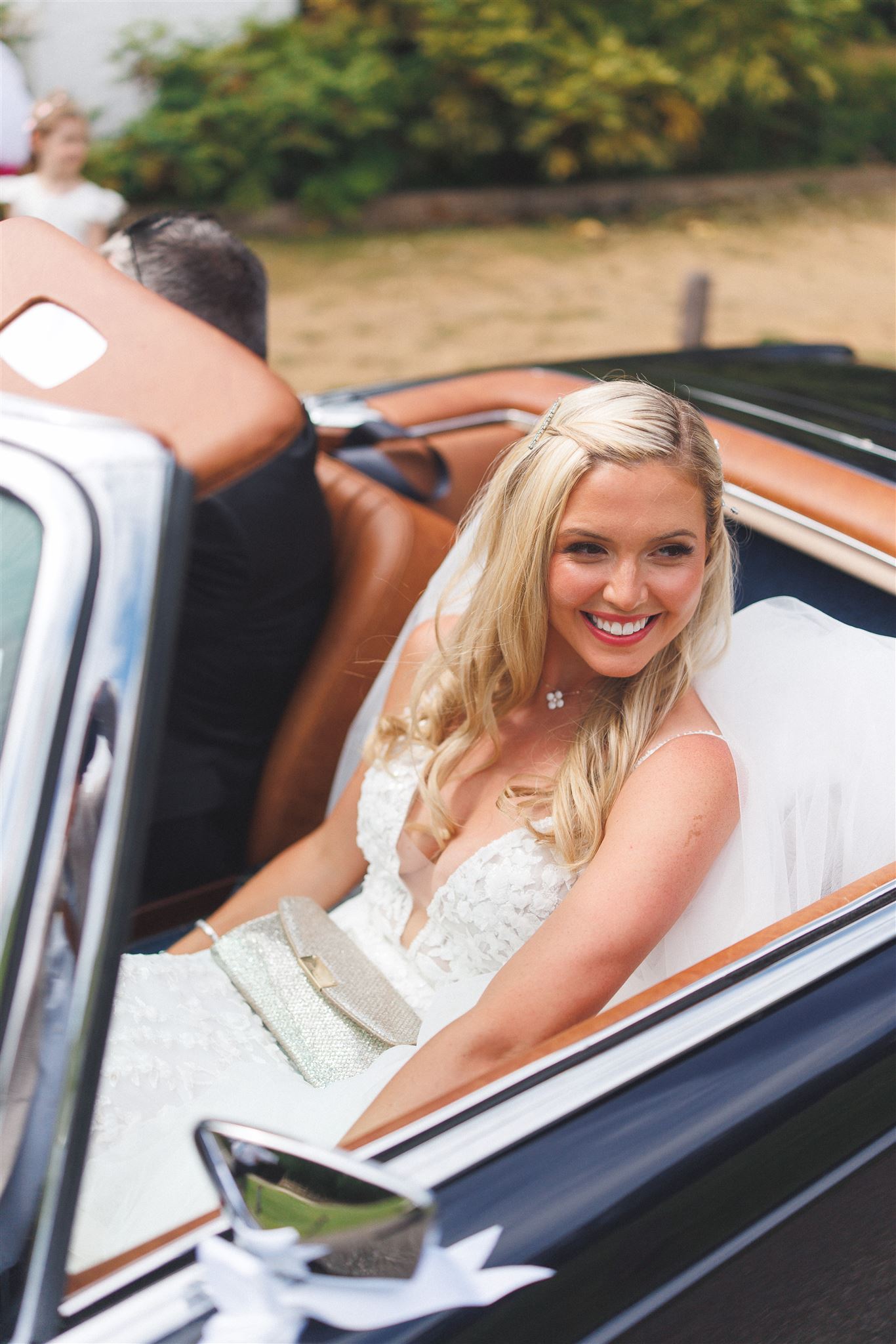 A bride laughing in the back of the wedding car