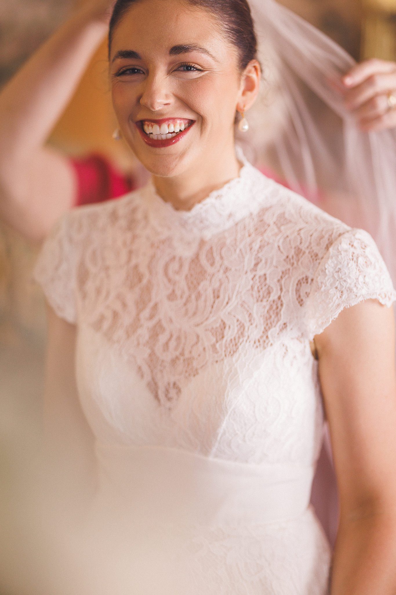 Lucinda laughing as her veil goes on