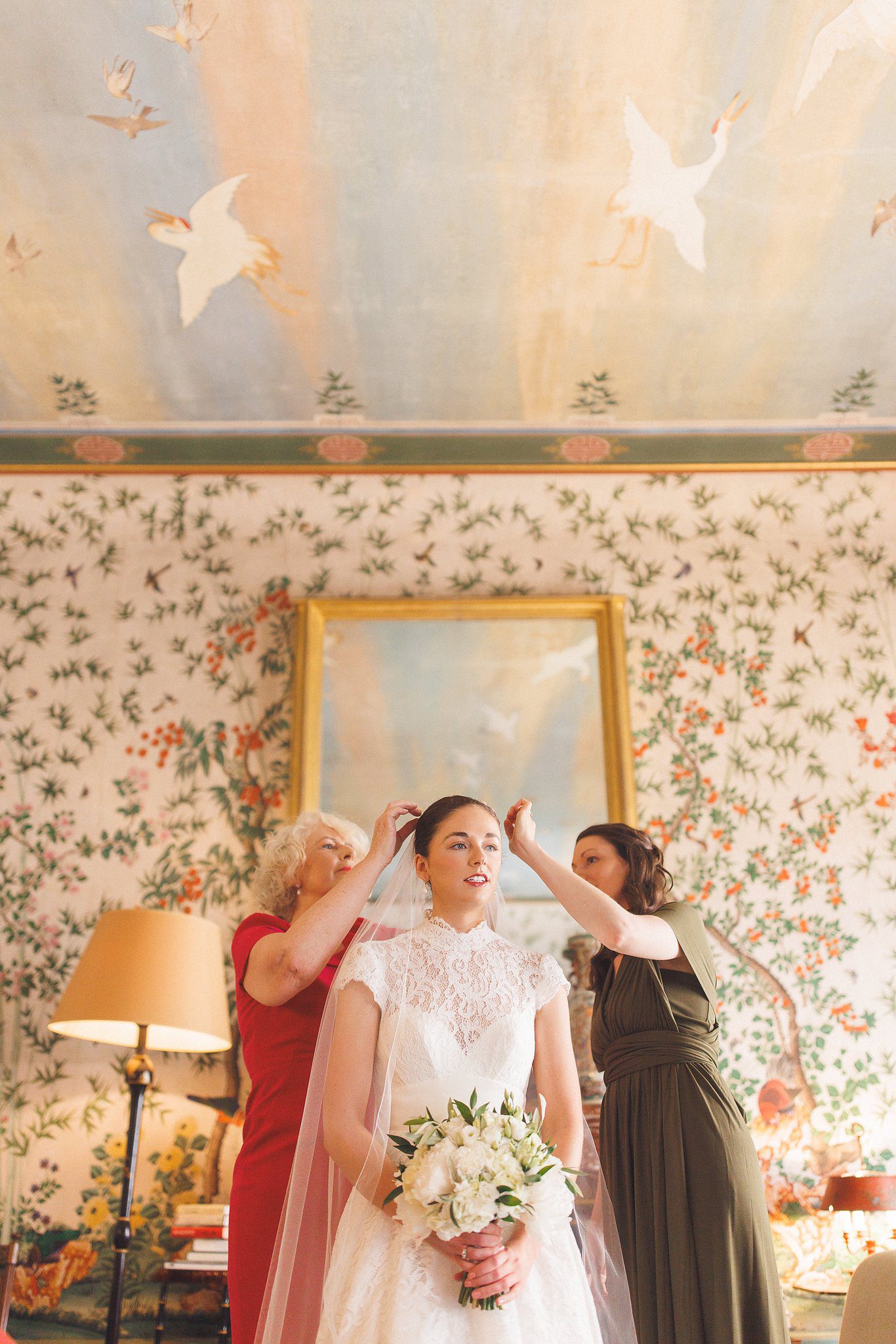 The bridesmaids fixing Lucinda’s veil in the bedroom