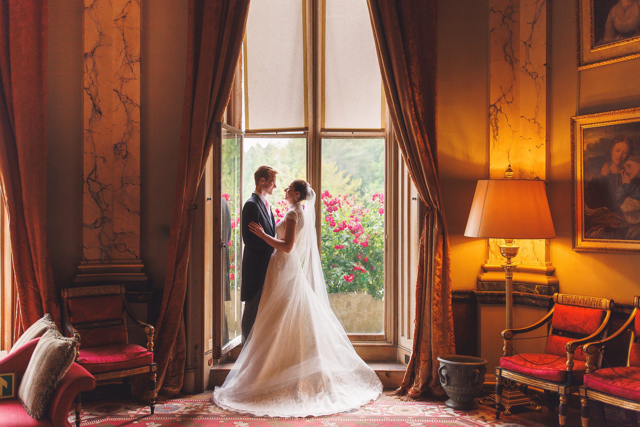 Lucinda and Tom by the window in the red drawing room