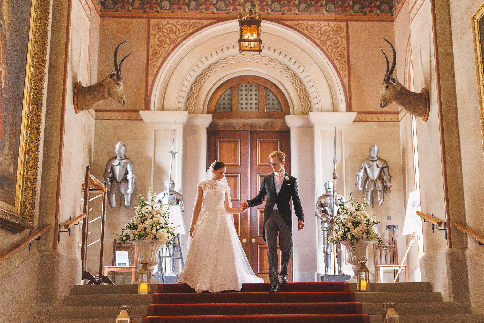 Lucinda and Tom coming down the red staircase